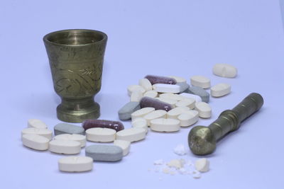 Close-up of medicines with mortar and pestle on table
