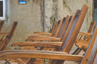 Wooden chairs in row against wall