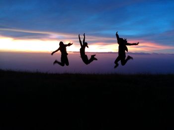 Silhouette man jumping against sky during sunset