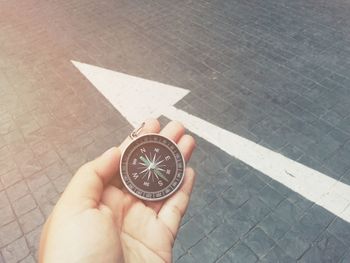 High angle view of person hand holding arrow symbol