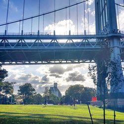 Bridge over river against cloudy sky