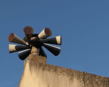 Low angle view of fire alarms on building against clear sky