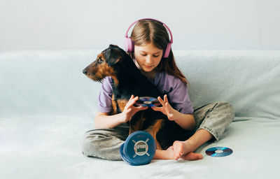 Portrait of woman with dog on sofa at home