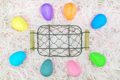 Directly above shot of easter eggs around basket on rug
