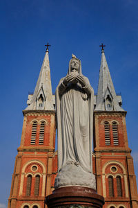 Low angle view of bell tower against blue sky