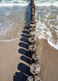 High angle view of wooden posts on beach