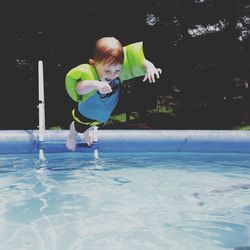 Girl jumping in swimming pool