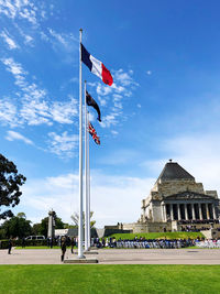 View of flags on building against cloudy sky