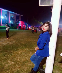 Full length portrait of woman standing at night