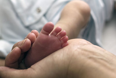 Cropped hand of person holding baby foot