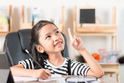 Portrait of a smiling young woman sitting on table