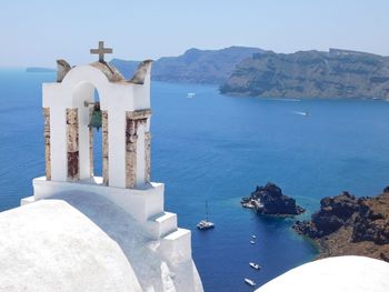Scenic view of sea by mountains against sky
