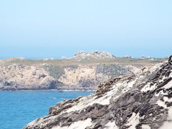 Scenic view of sea and mountains against clear sky