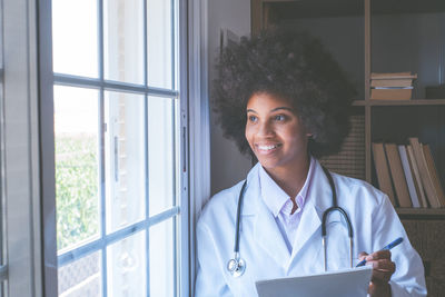 Female doctor smiling near window