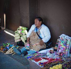 Full length of man sitting on multi colored indoors