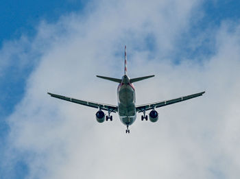 Low angle view of airplane flying against sky