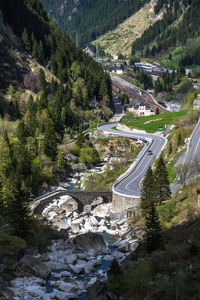 High angle view of winding road amidst trees against sky