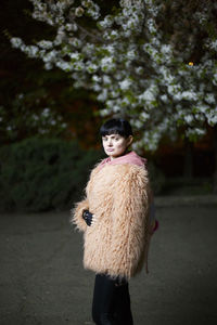 Portrait of woman standing against trees