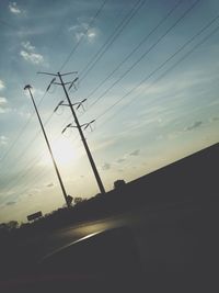 Cars on road against cloudy sky