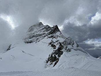 Low angle view of snowcapped mountains against sky