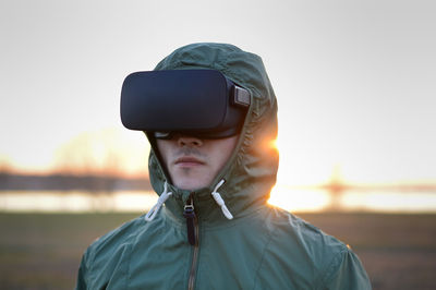 Man wearing virtual reality simulator standing on beach