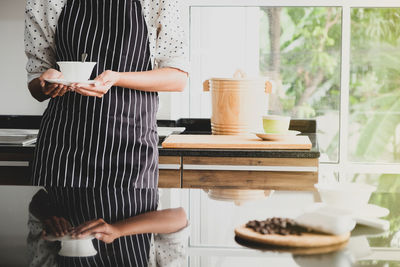 Midsection of woman having food at home