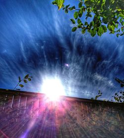 Sun shining through clouds over trees