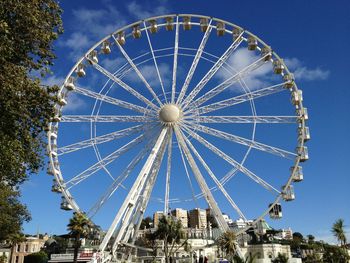 Low angle view of ferris wheel against blue sky