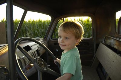 Portrait of smiling boy sitting in car