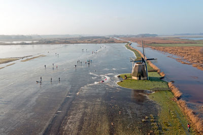 Aerial from ice skating at the ipey windmill in friesland the netherlands in winter