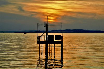 Silhouette sailboat on sea against sky during sunset