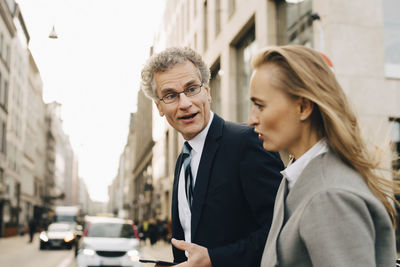 Side view of businessman talking to female colleague in city
