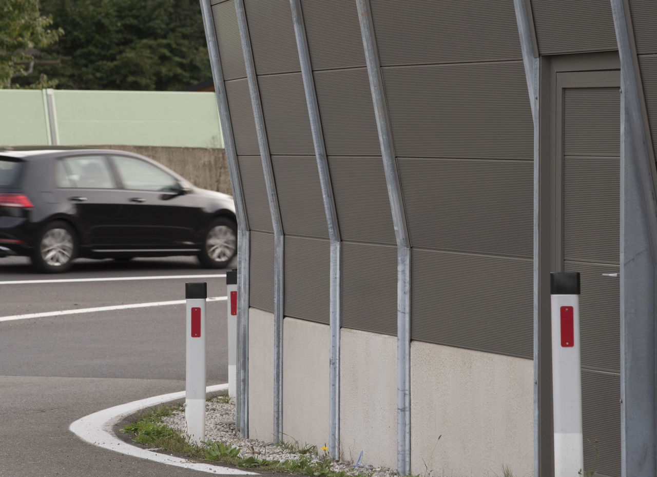 CARS PARKED BY ROAD AGAINST BUILDING