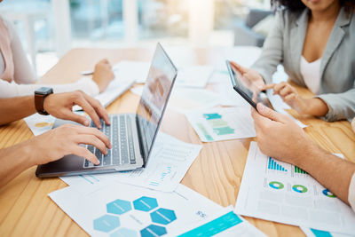 Midsection of business people working on table