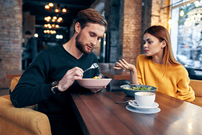 Young couple sitting on table at restaurant