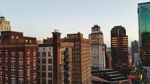 Buildings in city against clear sky