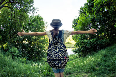 Rear view of woman standing against trees