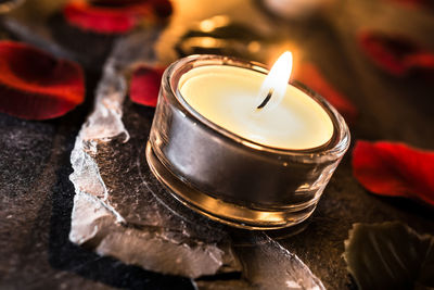 Close-up of lit tea light candle on table