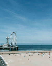 Ferris wheel at beach against sky