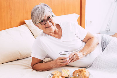 Midsection of woman sitting on table at home