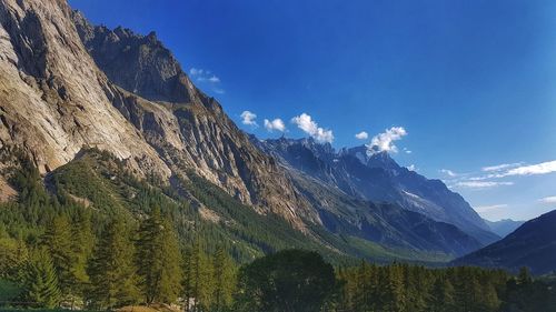 Scenic view of mountains against blue sky