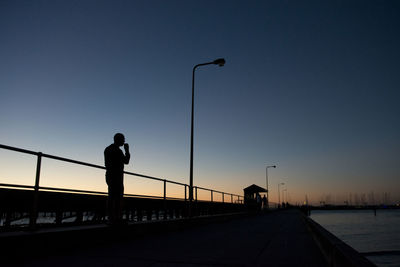 Silhouette of railing against sky at sunset