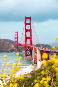 Golden gate bridge over bay against cloudy sky