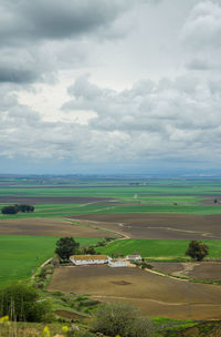 Scenic view of grassy field against cloudy sky