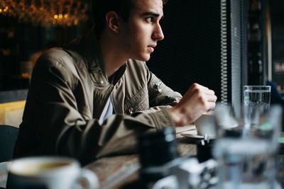 Close-up of man sitting at table in cafe