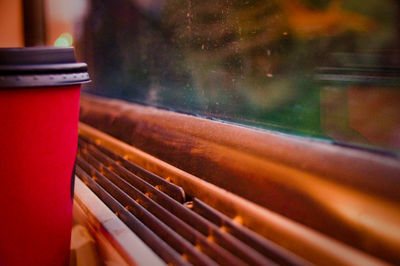 Close-up of disposable cup by window