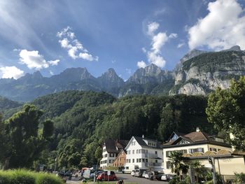 Panoramic shot of houses and trees against sky