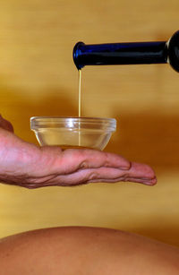 Pouring massage oil in a small bowl, health and wellness procedure