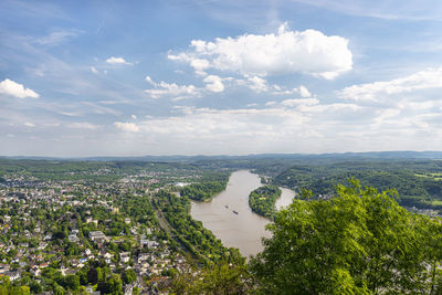 River rhein in western germany flowing along the city against the sky with clouds. visible ships.