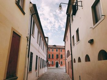 Street amidst buildings in town against sky